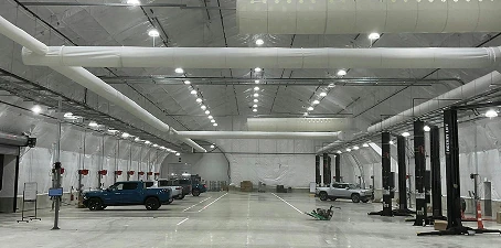 Automotive manufacturing facility flooring—clean, polished concrete floor in a large vehicle service and production space.”