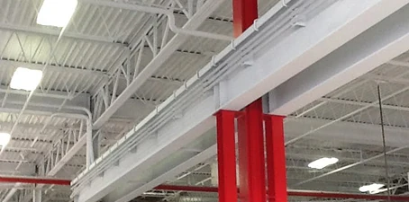 Ceiling painting—freshly painted industrial ceiling beams and supports in bright red and white.