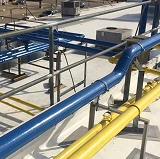 Industrial piping system painted in OSHA-compliant safety colors, with blue and yellow pipes clearly marked for hazard awareness and safety compliance.