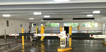 Parking garage painting—workers in protective gear painting and cleaning surfaces in a multi-level garage.